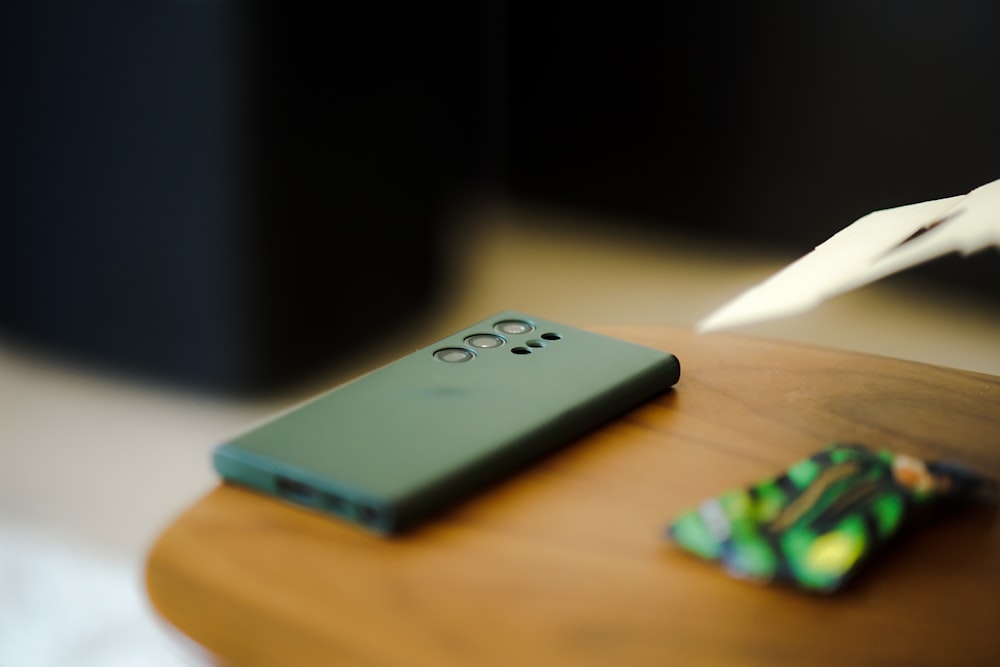 a green cell phone sitting on top of a wooden table