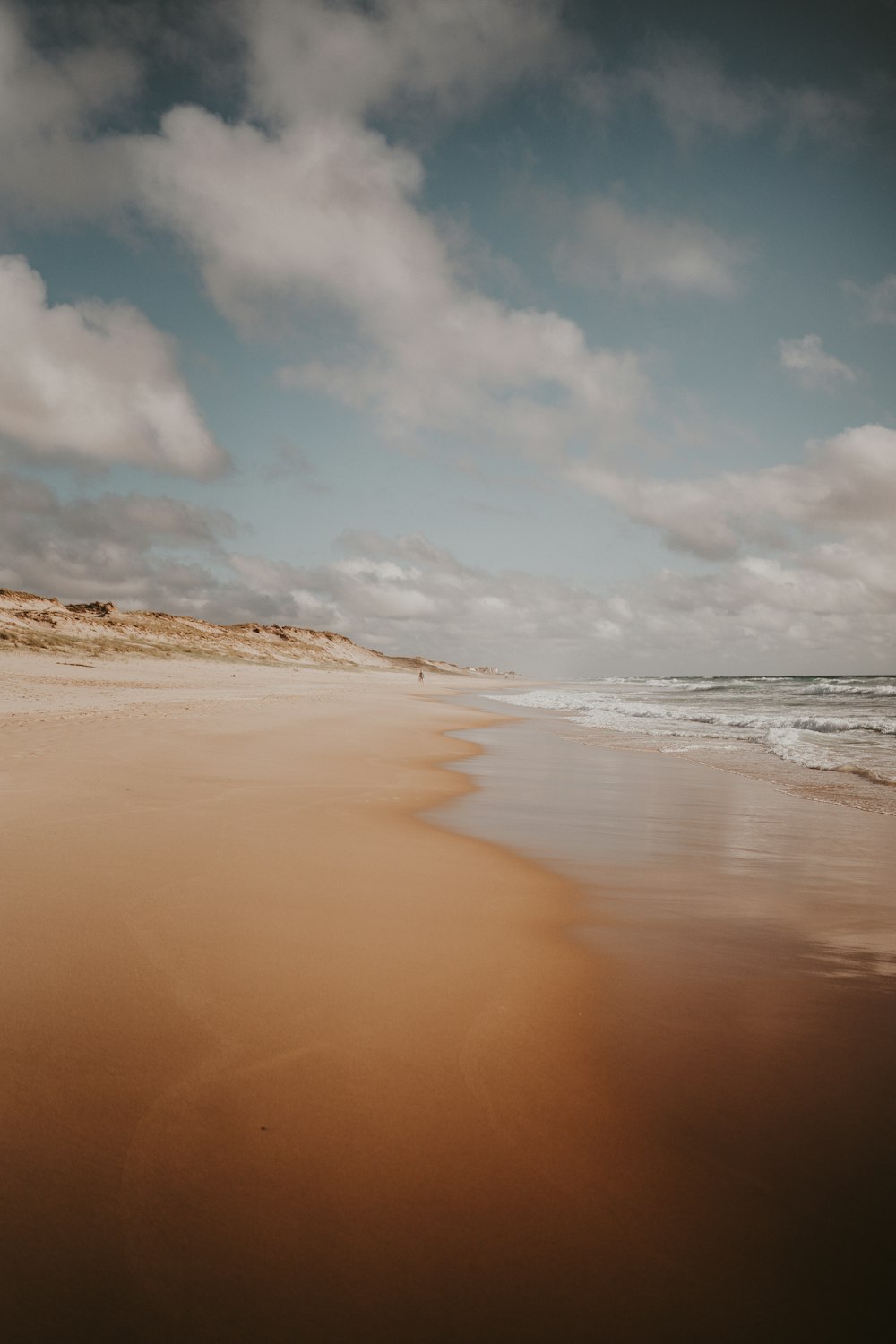 a sandy beach with waves coming in to shore