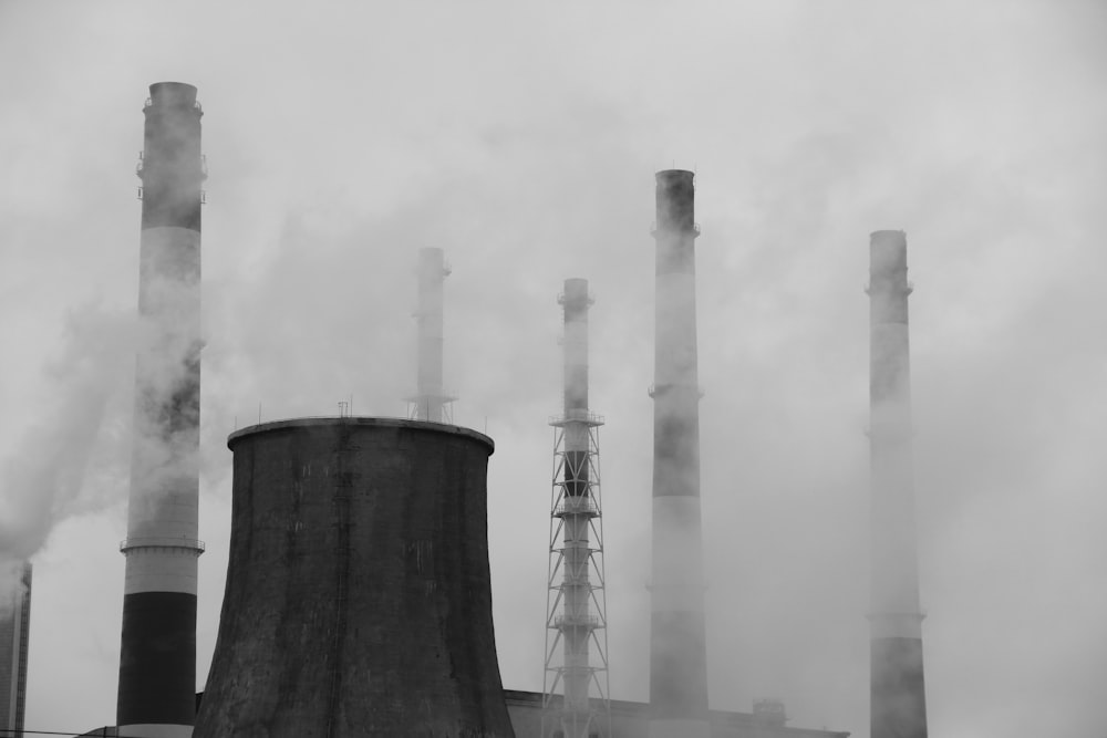 a black and white photo of smoke coming out of a factory