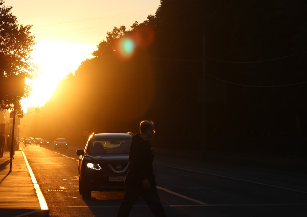 a person walking down a street at sunset