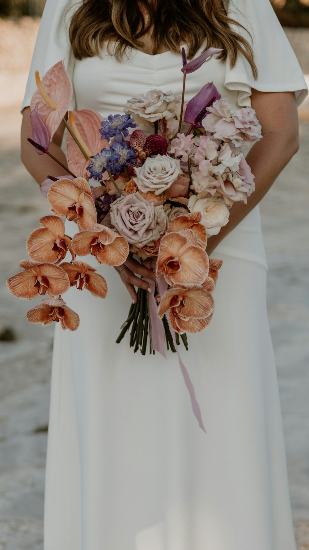 a woman in a white dress holding a bouquet of flowers