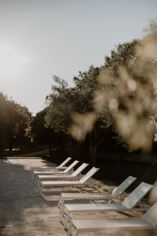 A serene outdoor lounge area showcasing Vivanest’s elegant chaise lounge at sunset.