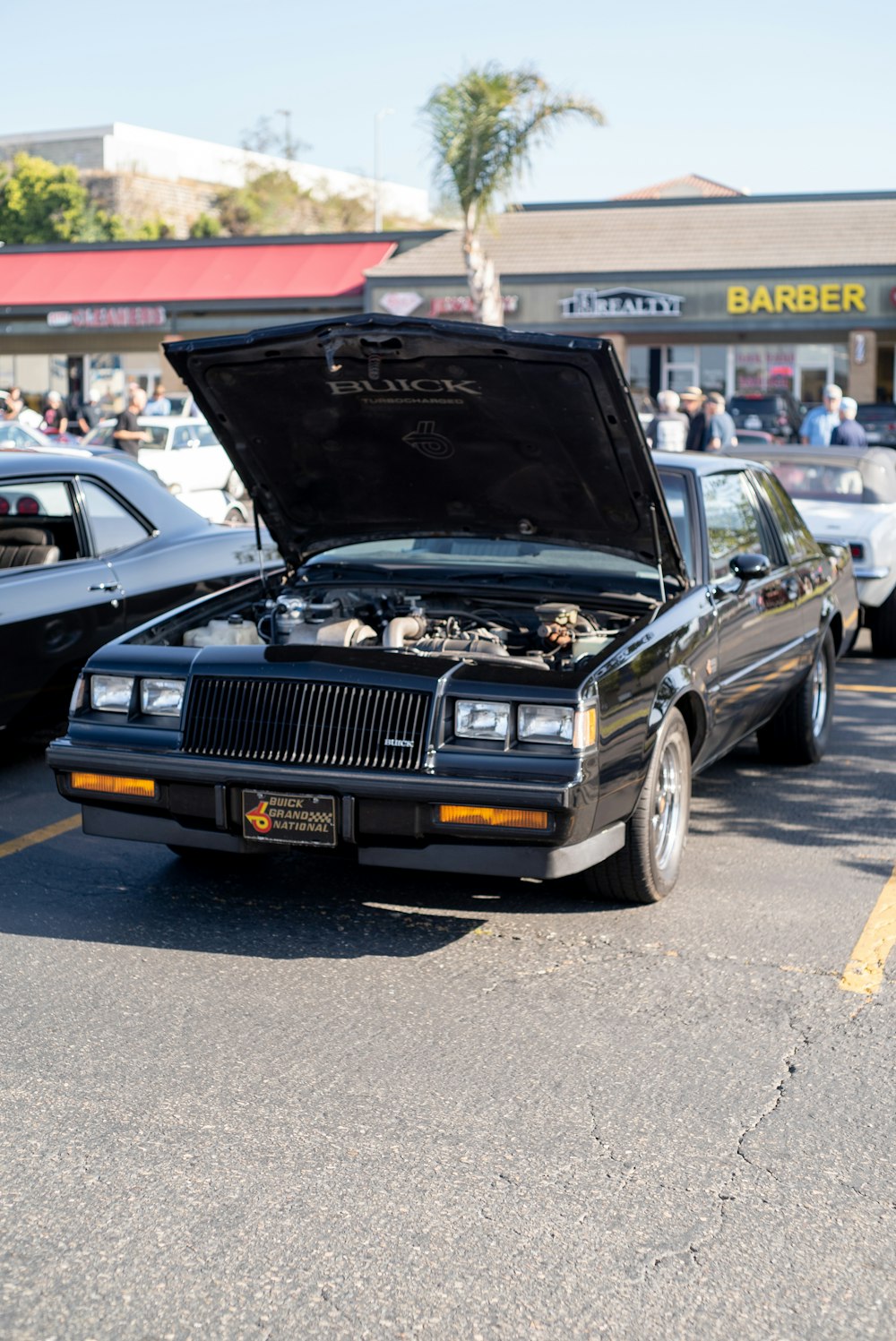 a car with its hood open in a parking lot