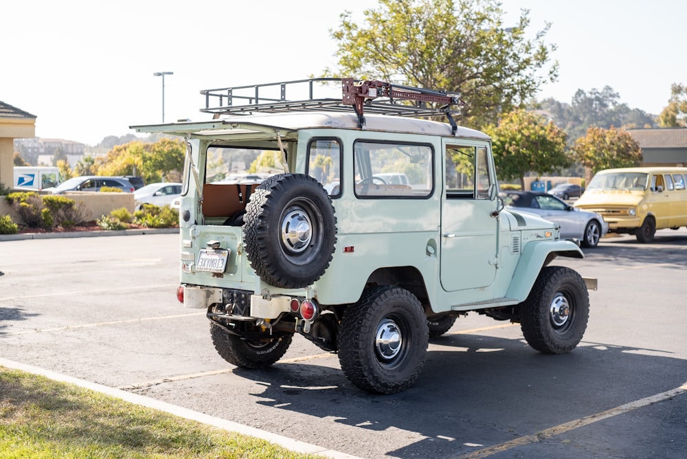 a light green jeep parked in a parking lot