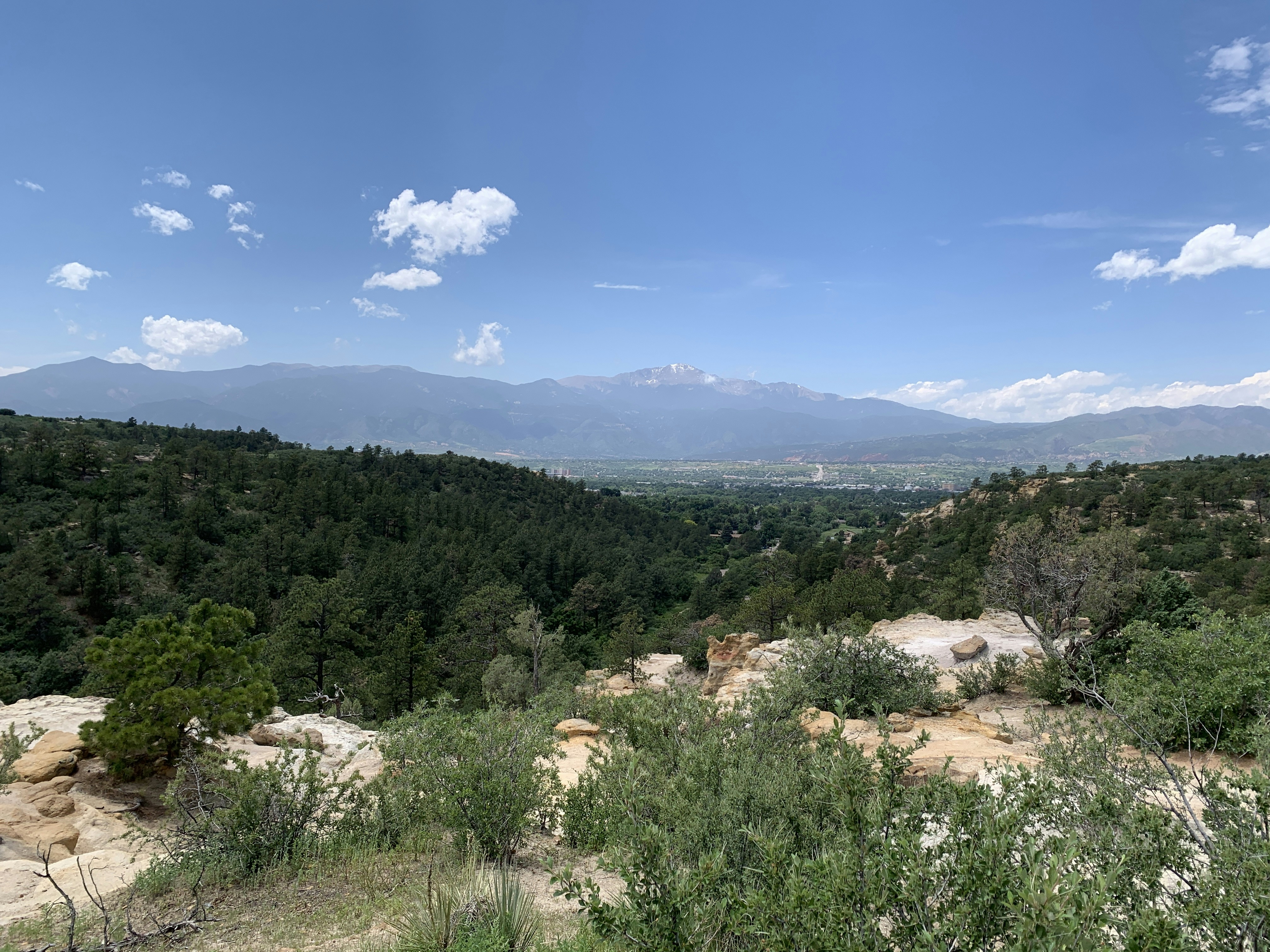 a view of a mountain range with trees and mountains in the distance