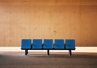 A peaceful waiting area featuring minimalist decor in beige hues and ocean blue accents, inviting calm and relaxation.