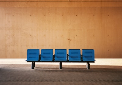 A peaceful waiting area featuring minimalist decor in beige hues and ocean blue accents, inviting calm and relaxation.