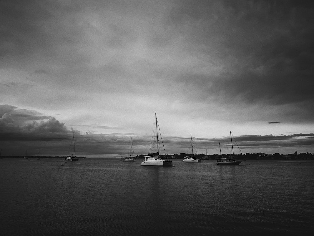 a black and white photo of boats in the water