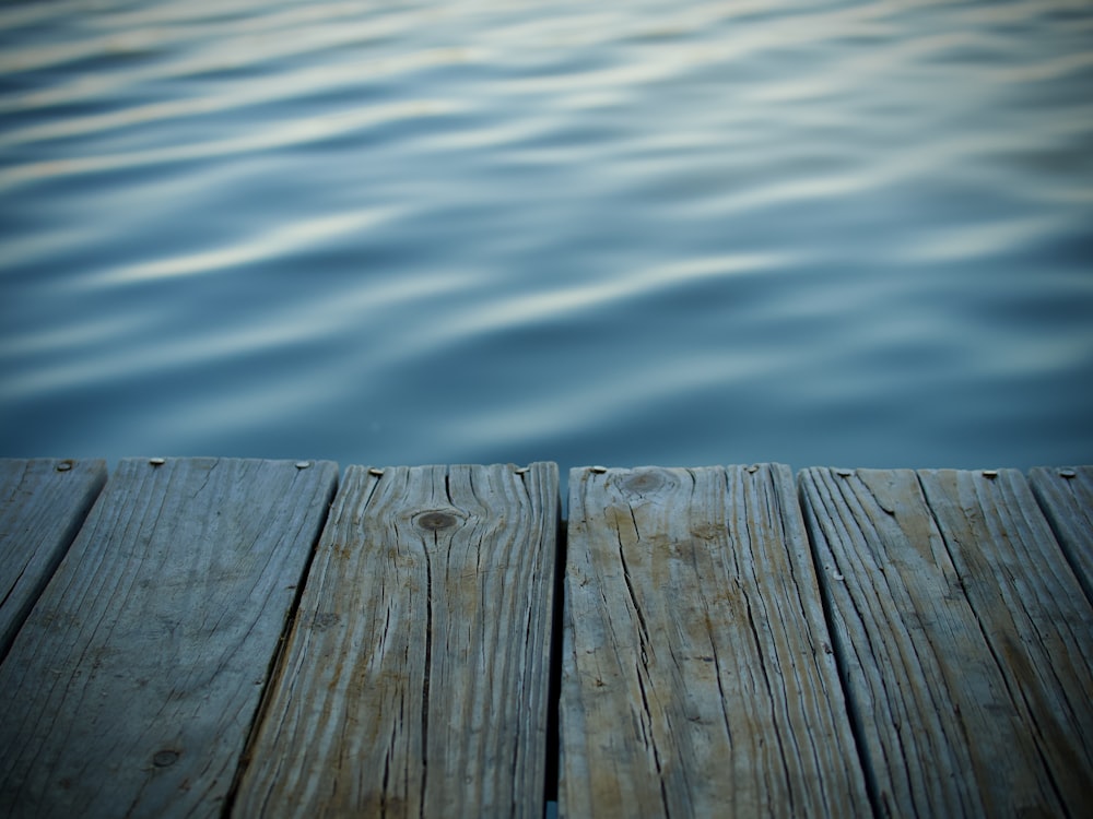 a wooden dock with water in the background