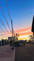 A vibrant sunset over the lush green riverbanks of Parque Las Riberas with families enjoying the open space.