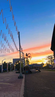 A sunset view of Phoenix’s skyline with community members gathered in a park for an evening event hosted by Voces del Valle.