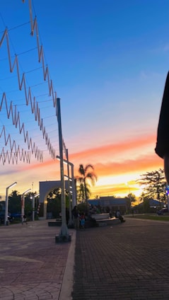 A vibrant sunset over the lush green riverbanks of Parque Las Riberas with families enjoying the open space.