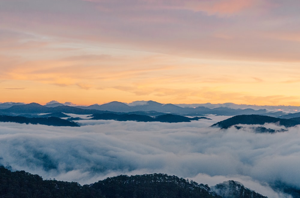 a view of a mountain range covered in clouds