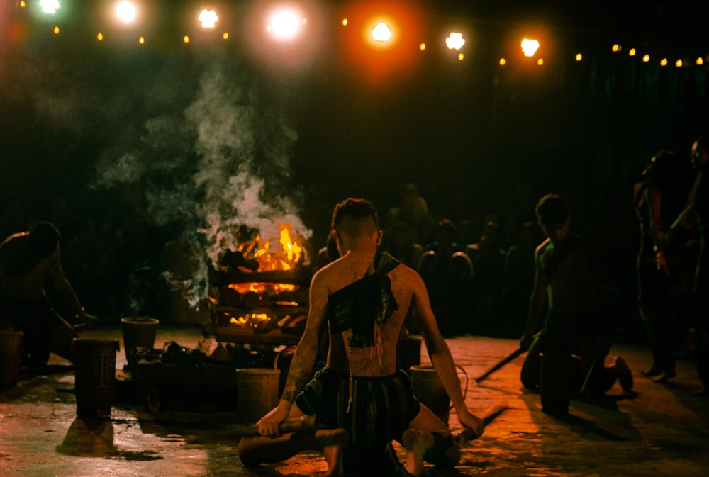 a group of people standing around a fire pit