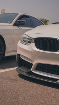 A close-up shot of two different car models side by side on a sunny day, highlighting their design contrasts.