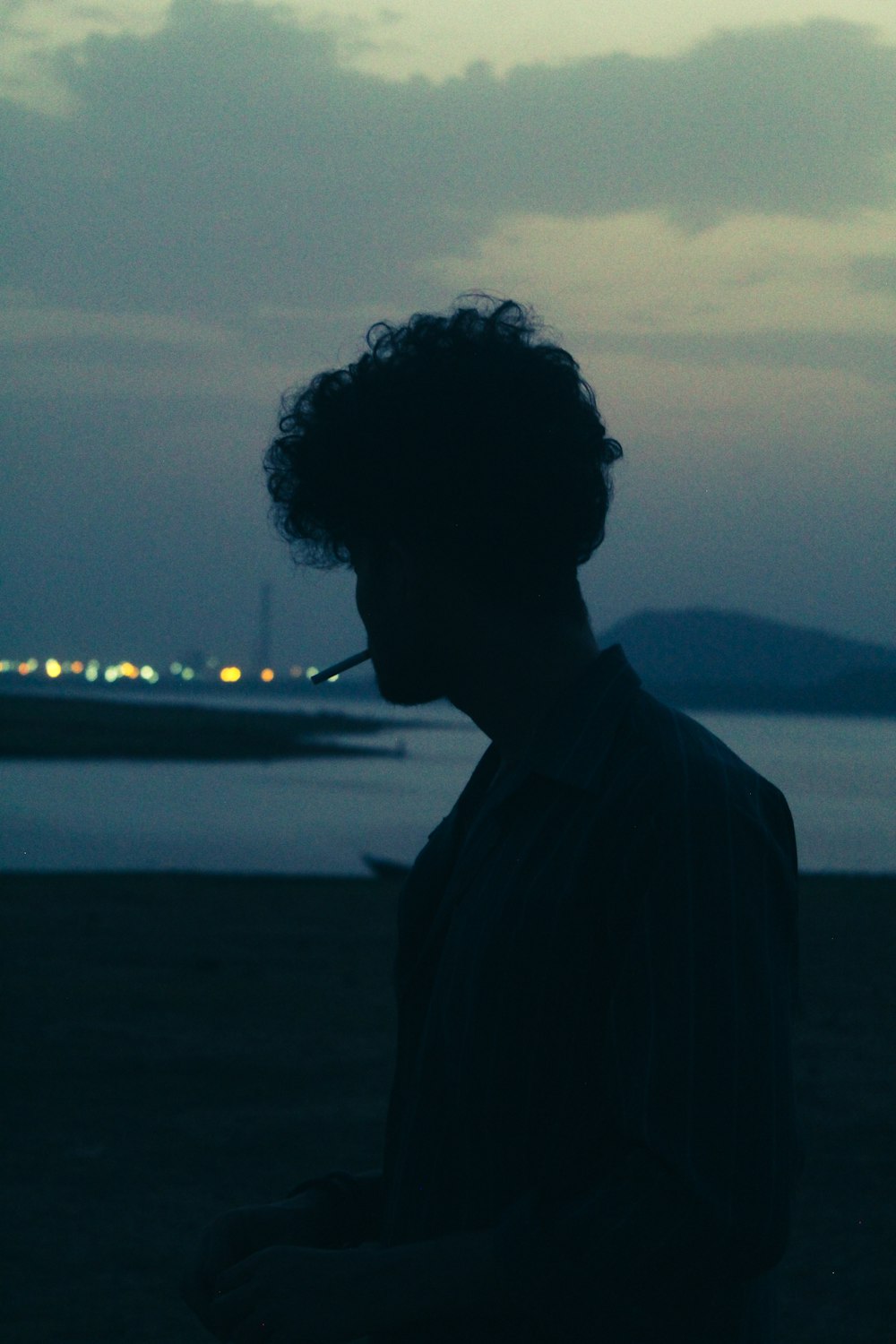 a man standing in front of a body of water