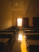 Sunbeam filtering through curtains onto an old-fashioned school desk with chalk and notebooks.
