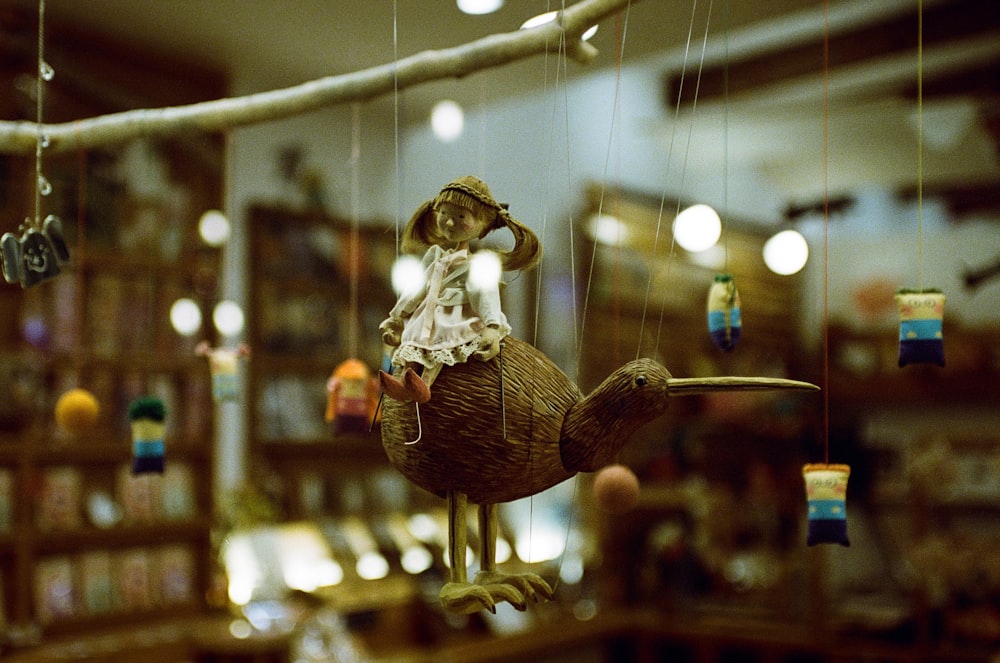 a figurine of a girl riding a bird on a string