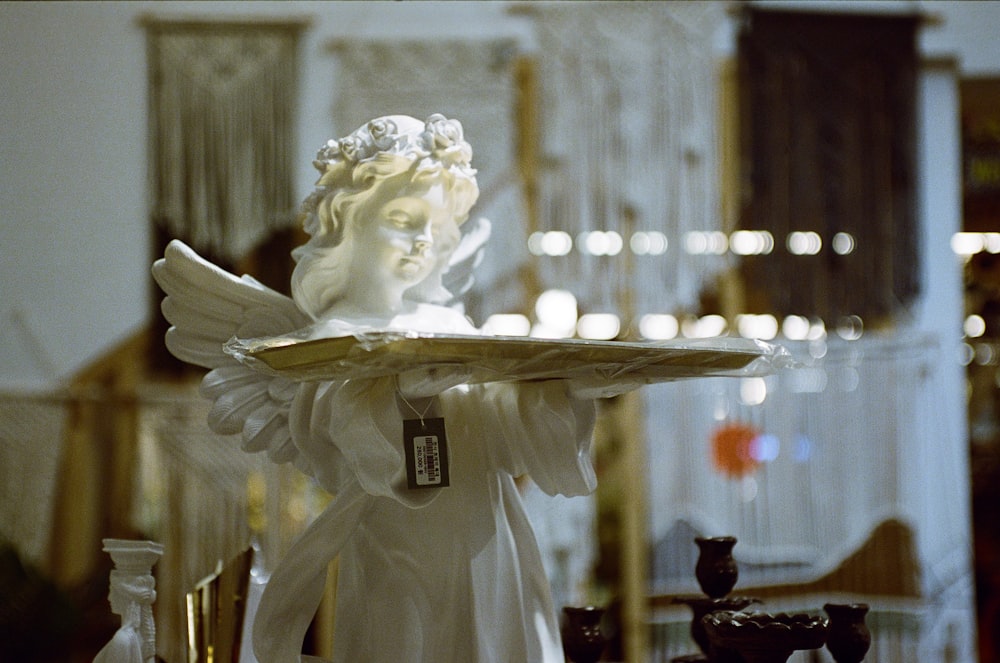 a statue of an angel holding a tray