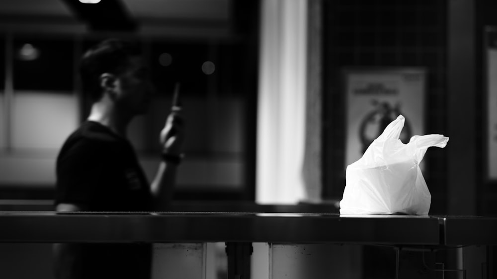 a black and white photo of a person holding a cell phone