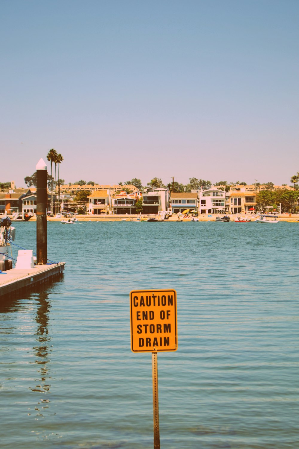 a caution sign is in the water near a dock