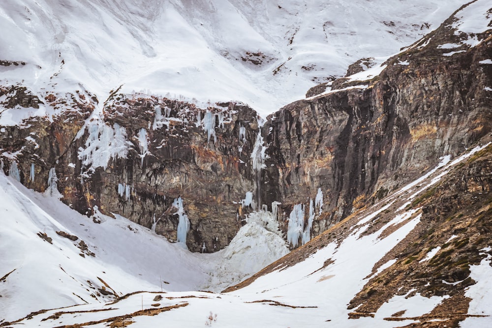 a snow covered mountain with ice hanging off of it's sides