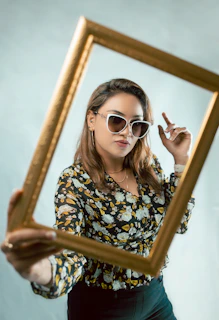 Sophisticated woman holding a beautifully designed affirmation print framed in natural wood