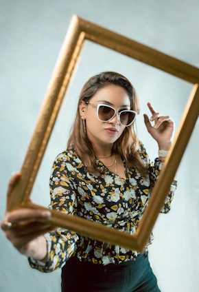 Sophisticated woman holding a beautifully designed affirmation print framed in natural wood