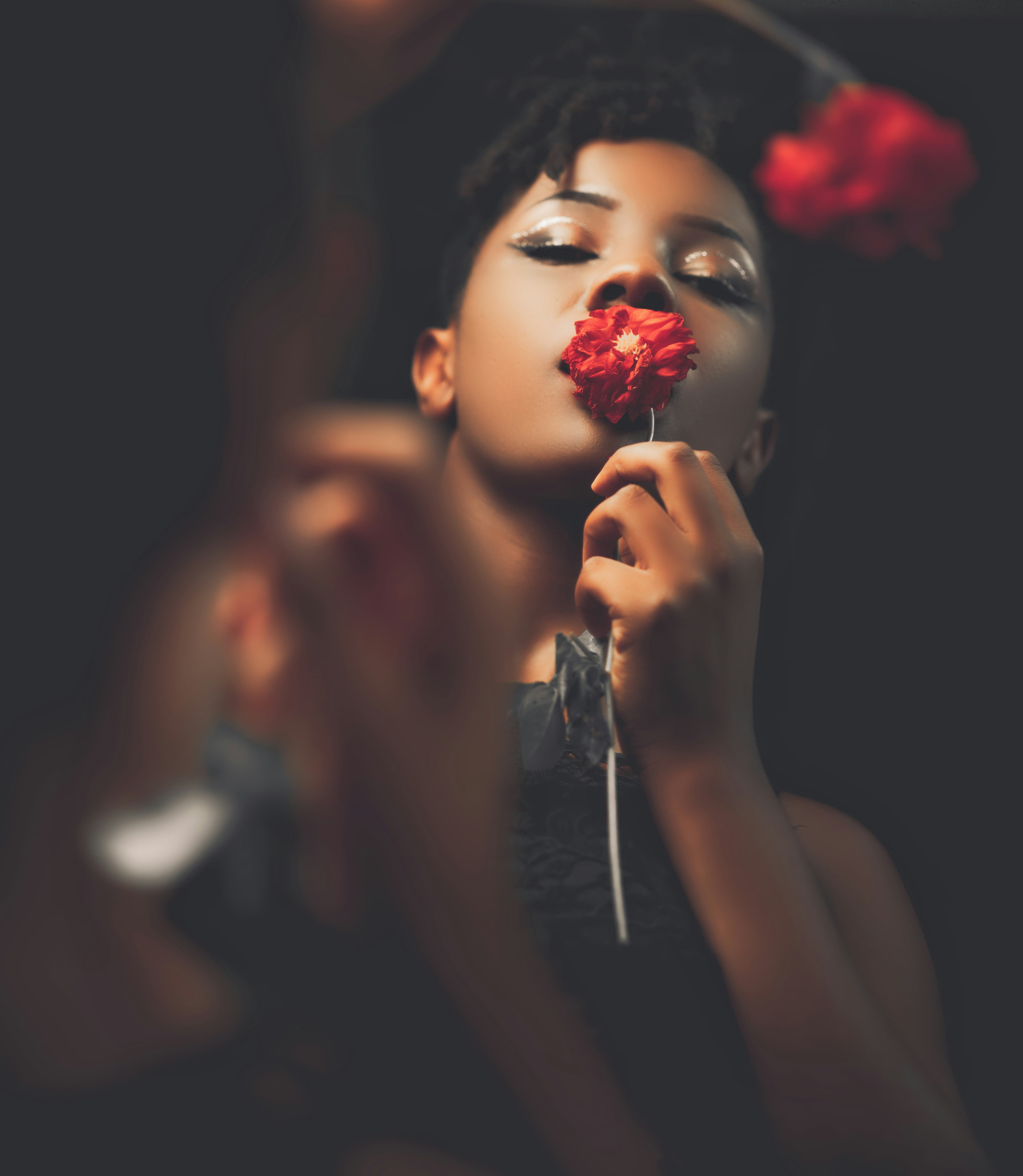 A woman holding a flower in front of her face photo – Free Canada Image ...
