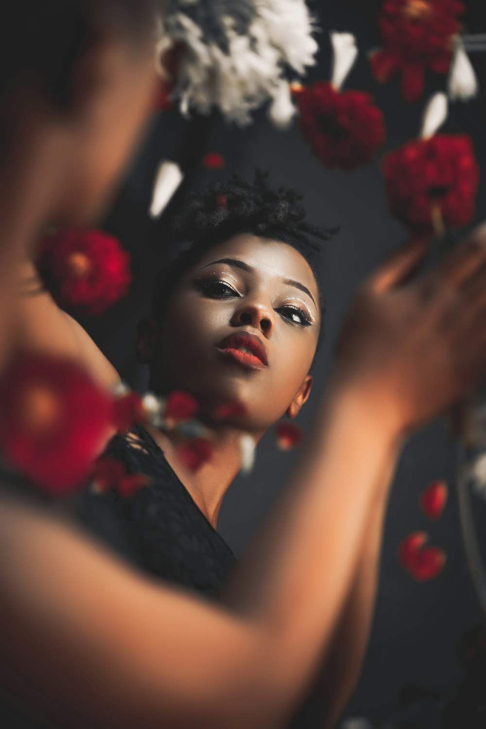 a woman in a black dress holding a bunch of flowers