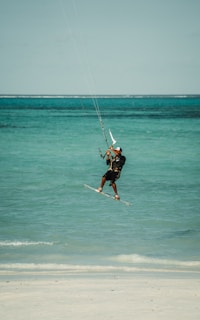 a man flying a kite on top of the ocean