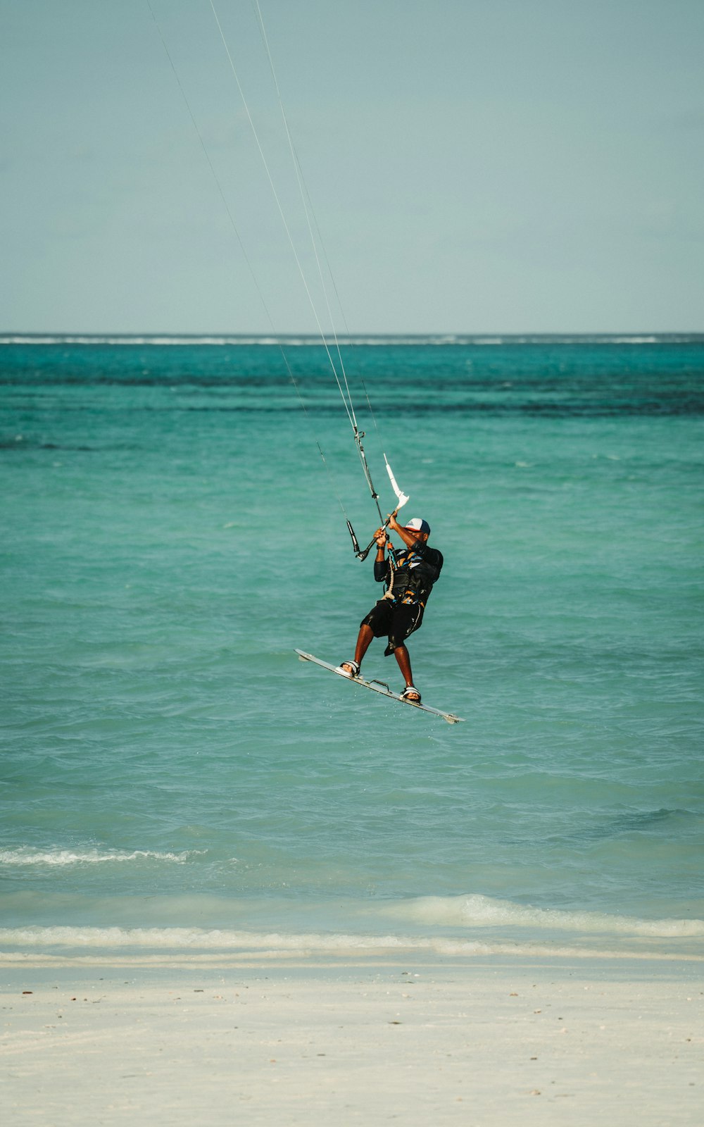 a man flying a kite on top of the ocean