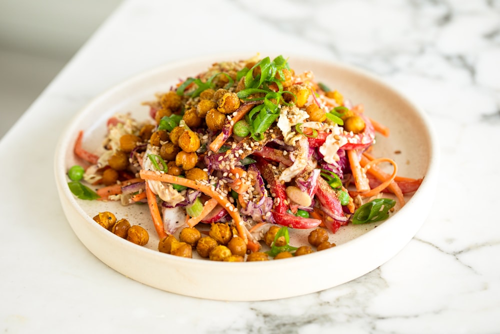 a white bowl filled with a salad on top of a table