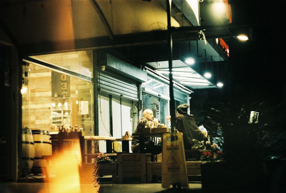 Un hombre sentado en una mesa frente a una tienda