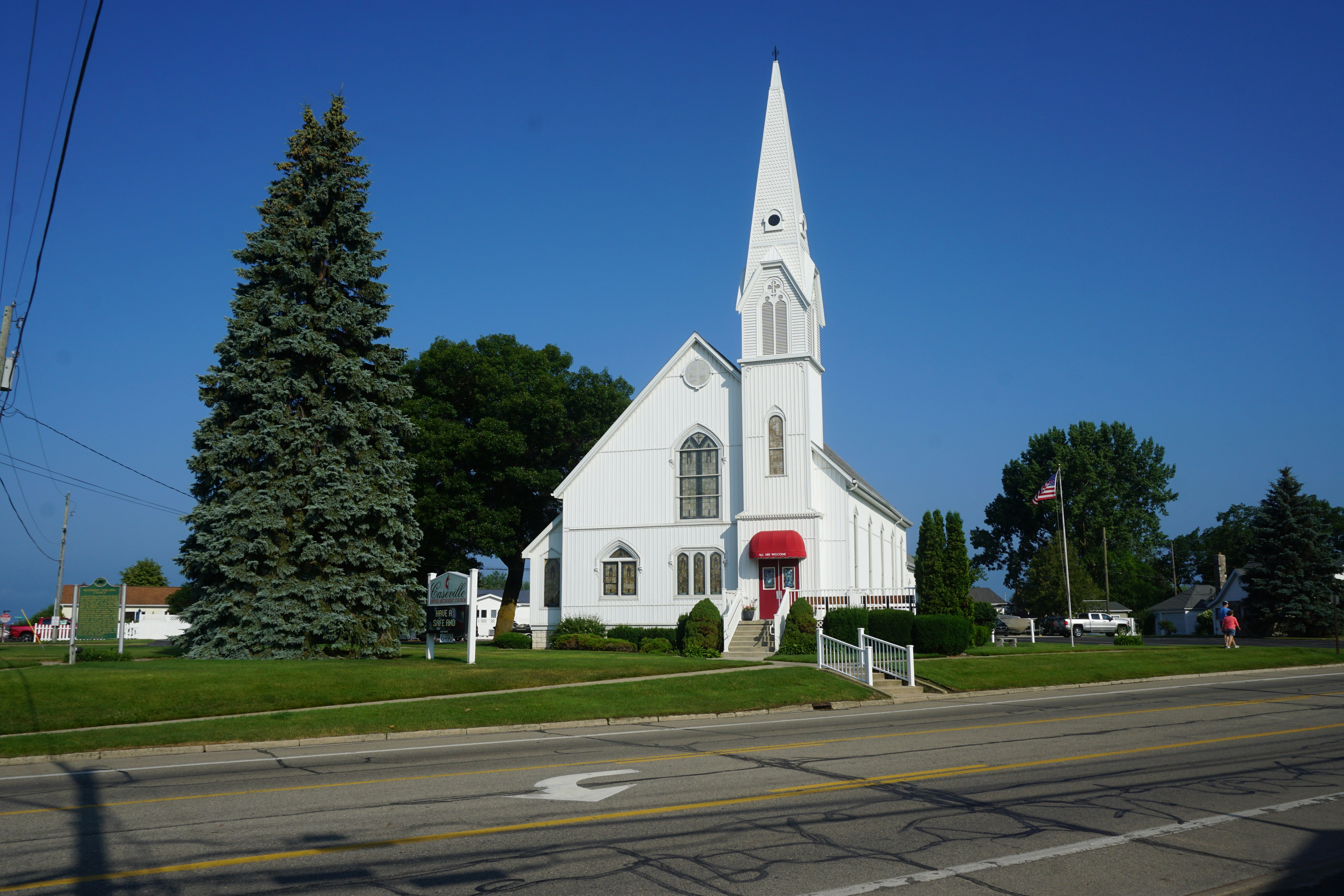 a white church with a steeple and a red door
