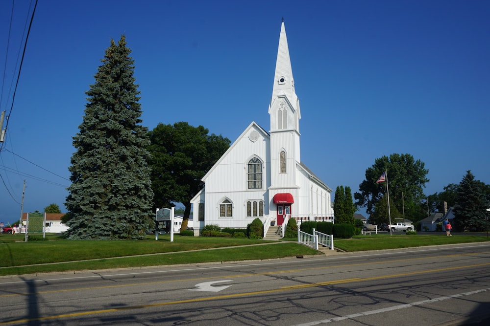 a white church with a steeple and a red door