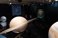 A virtual tour scene of the science museum featuring 3D models of famous experiments.