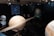 A museum exhibit featuring large models of planets, including Saturn with its rings, and other celestial objects displayed against a backdrop of stars. Screens present images of a galaxy and a star cluster.