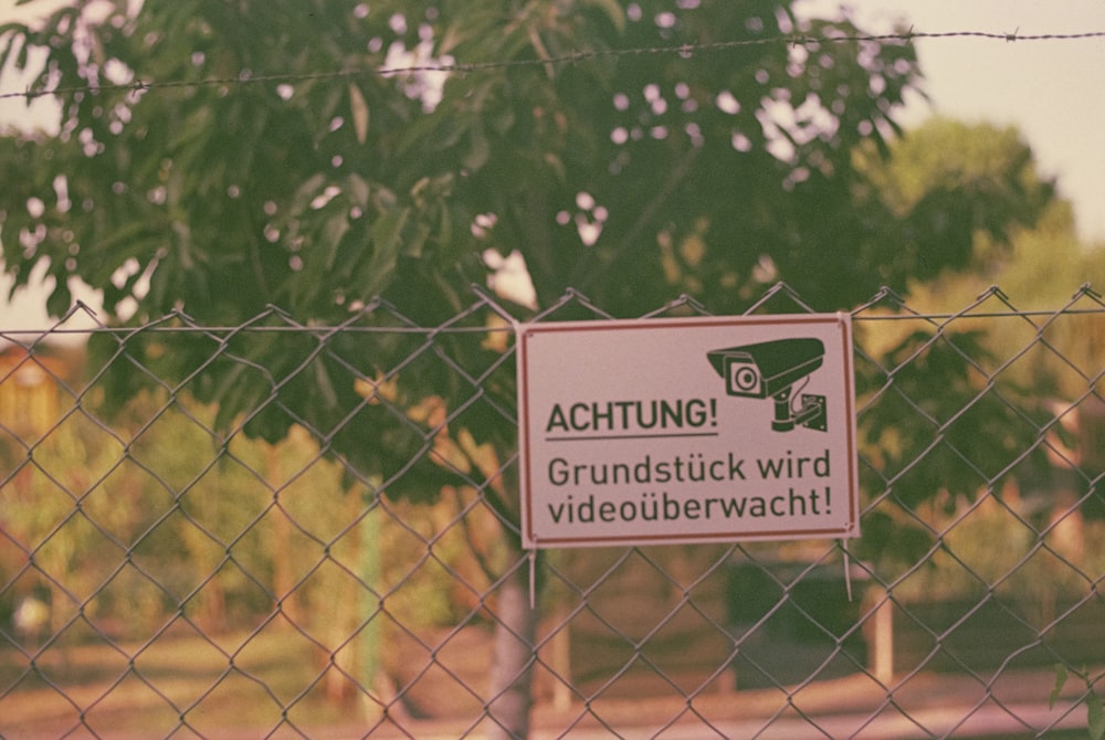 a sign is posted on a chain link fence