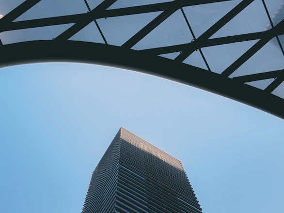 A sleek steel frame of a modern building under construction against a clear sky.