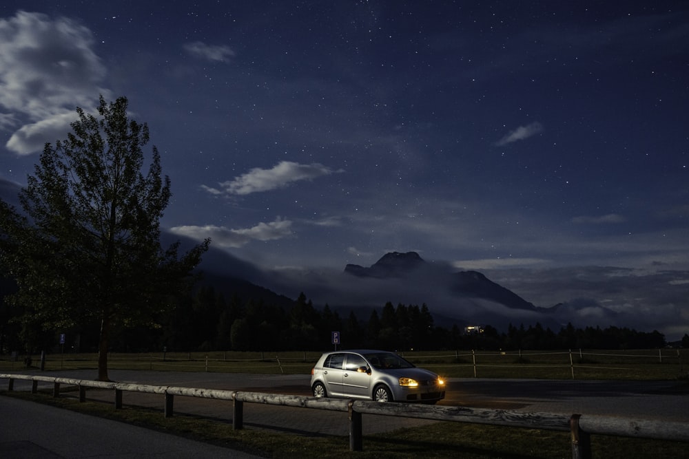 a car parked on the side of a road at night