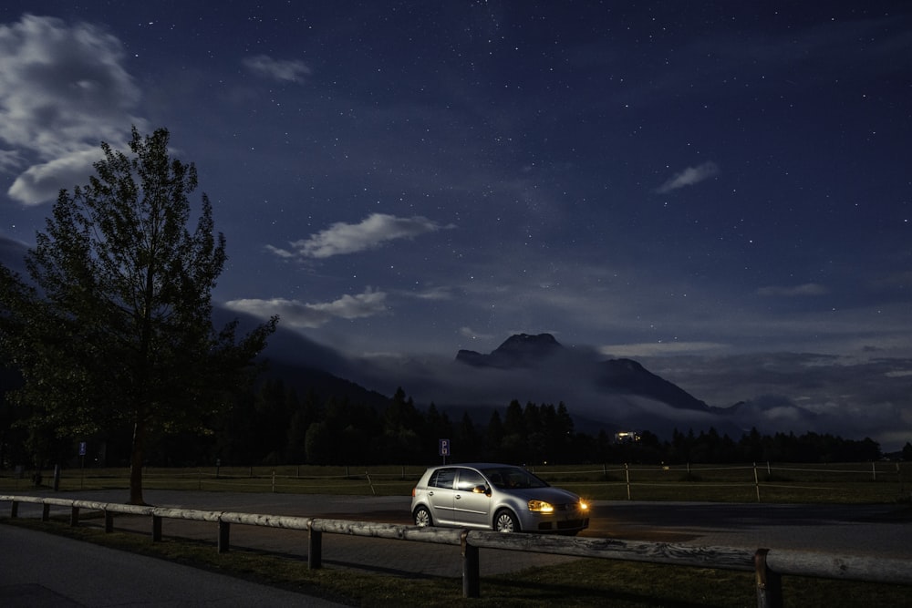 un'auto parcheggiata sul ciglio di una strada di notte