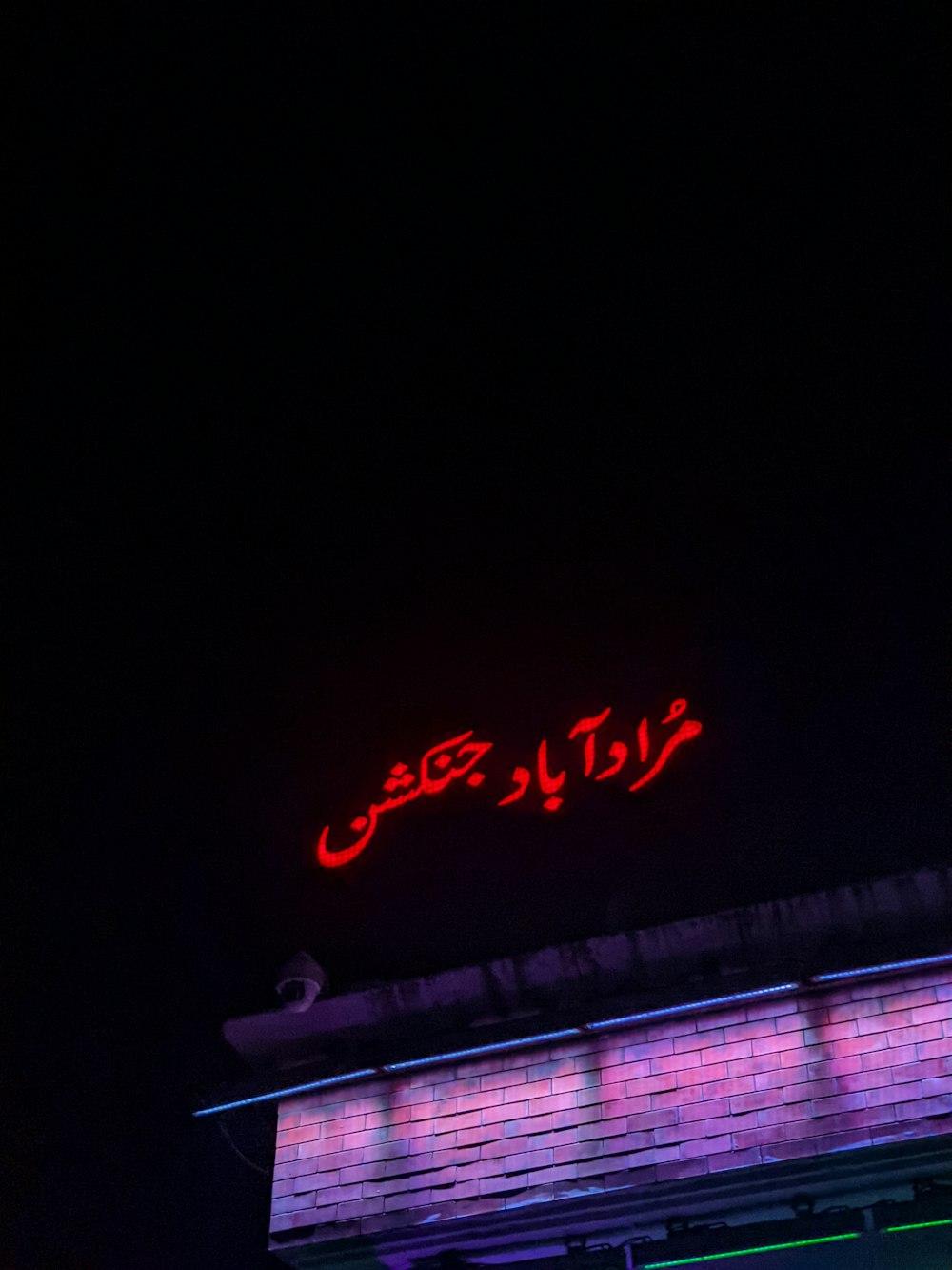 a red neon sign on top of a building