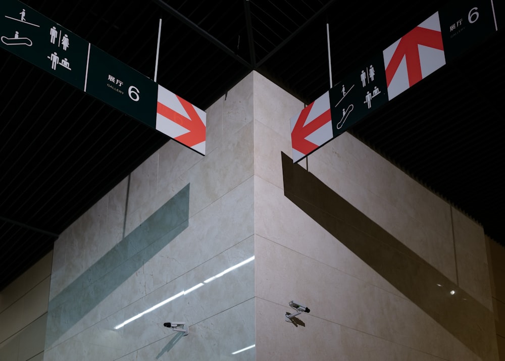 two street signs hanging from the ceiling of a building