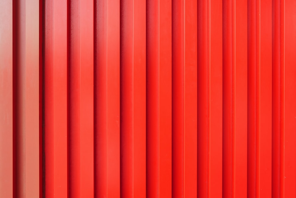 a close up of a red wall with vertical lines
