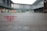 A glass window with a frosted design displays text and a logo in red, with the words 'China Art Museum Shanghai' visible. The background shows an outdoor view of modern architectural structures, slightly blurred.