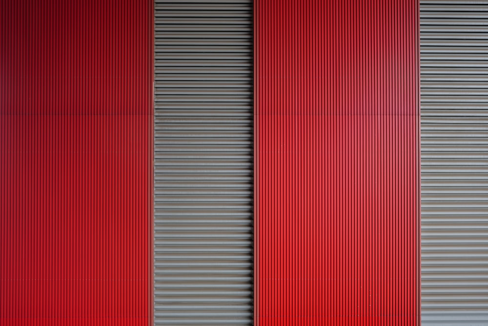 a red and grey wall with vertical blinds