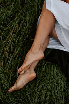 Close-up of bare feet gently touching grass in a peaceful garden.
