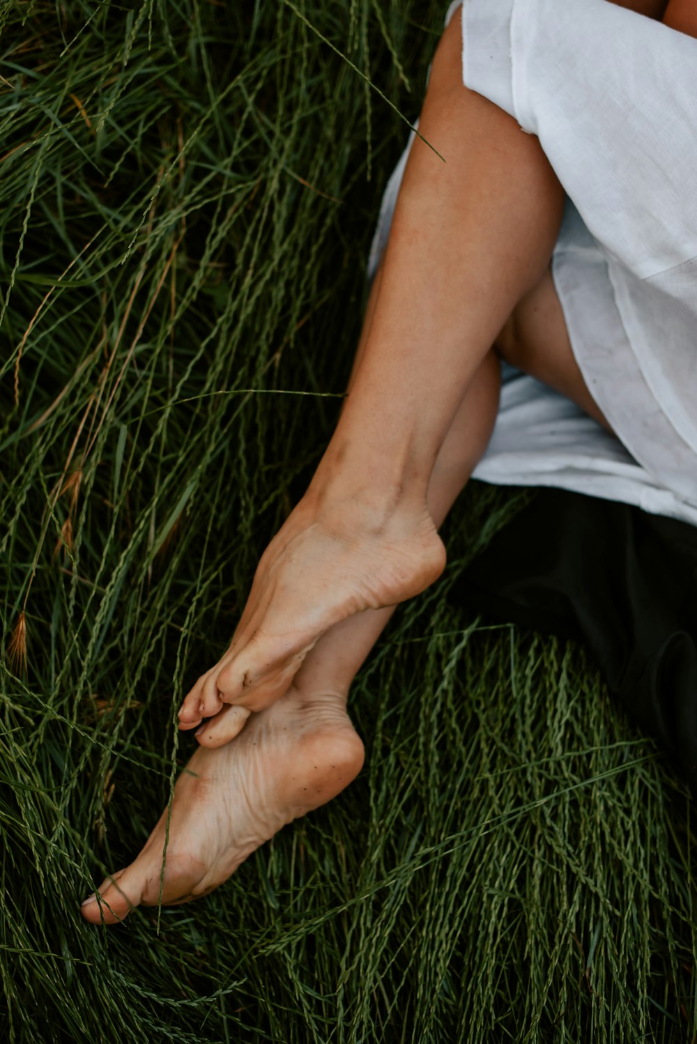 a person laying in the grass with their feet up