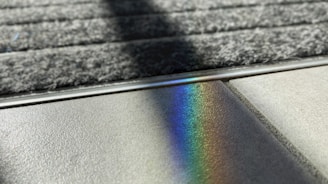 a rainbow of light shining on the surface of a rug
